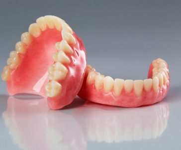 Full set of dentures on reflective off-white surface