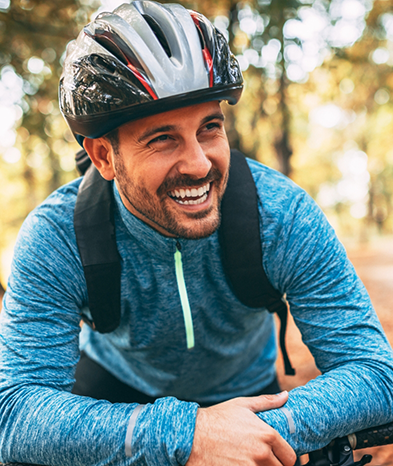 Man with helmet riding bike and smiling