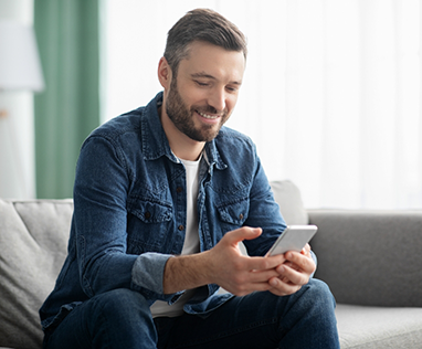 Man sitting on couch looking at phone